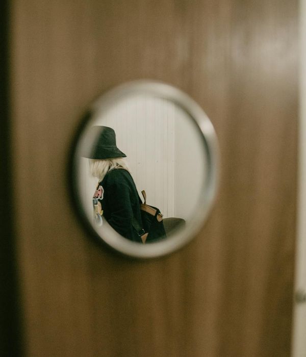 Person stretching in a minimalist room with warm ambient light.